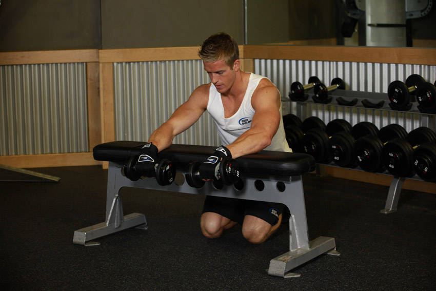 How to perform the Palms-Down Dumbbell Wrist Curl Over A Bench exercise
