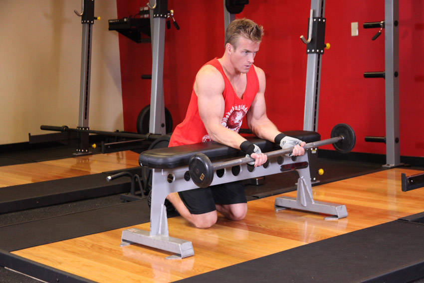 How to perform the Palms-Up Barbell Wrist Curl Over A Bench exercise